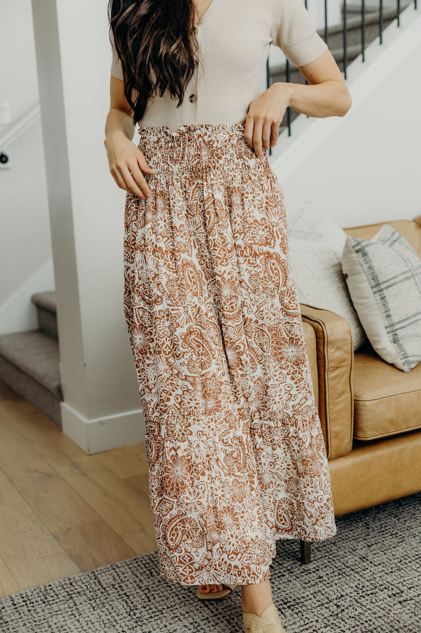 Full length smocked waist tiered skirt with rust print.
