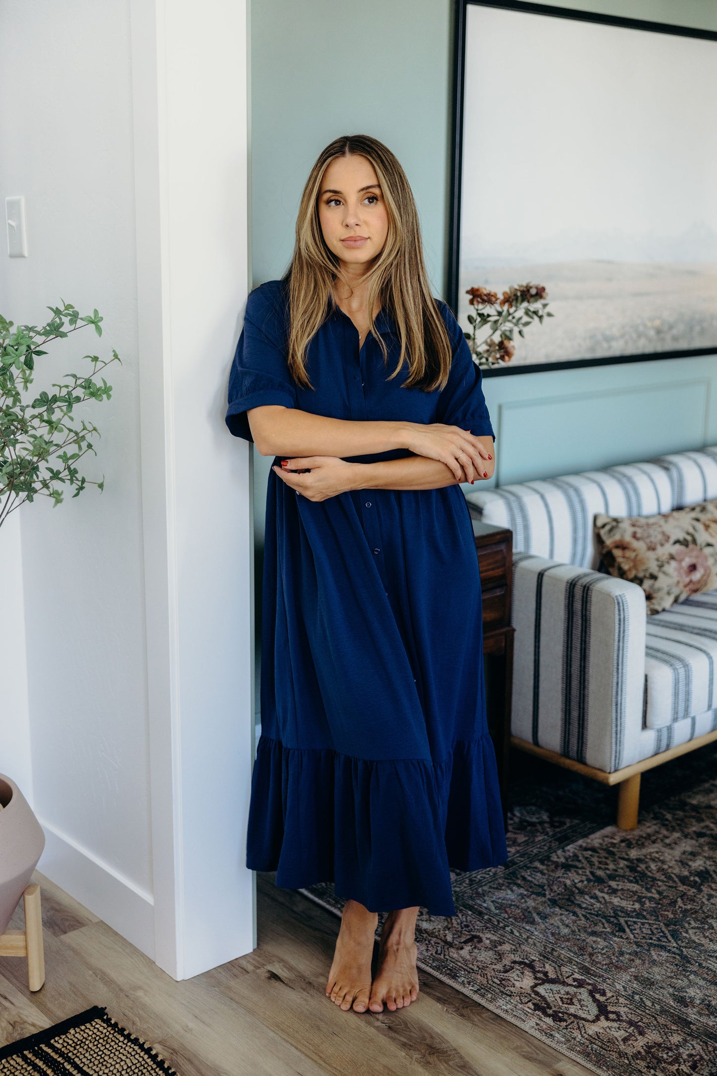 Full length dark blue dress with ruffle hem and short sleeves.