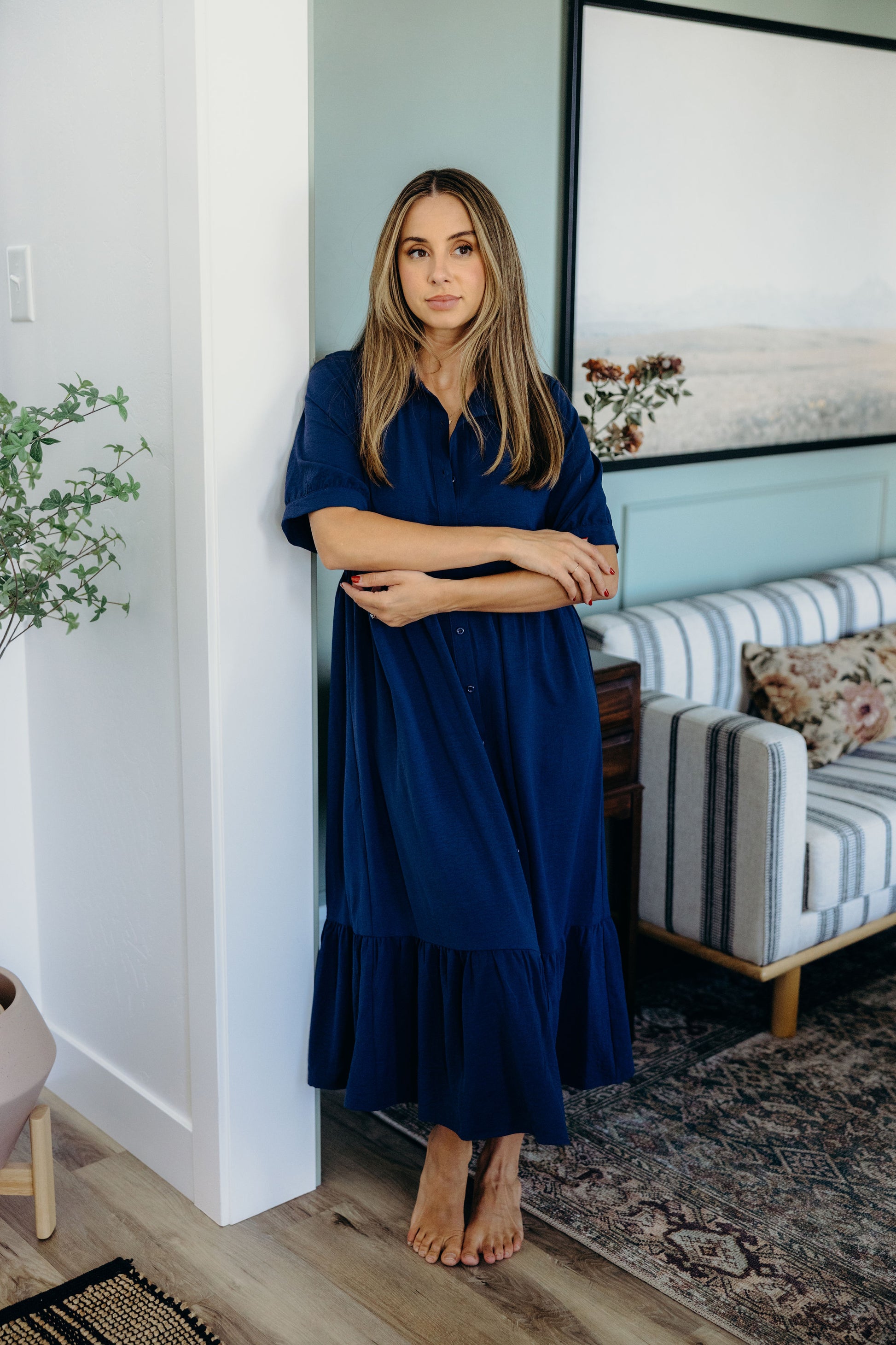 Full length dark blue dress with ruffle hem and short sleeves.