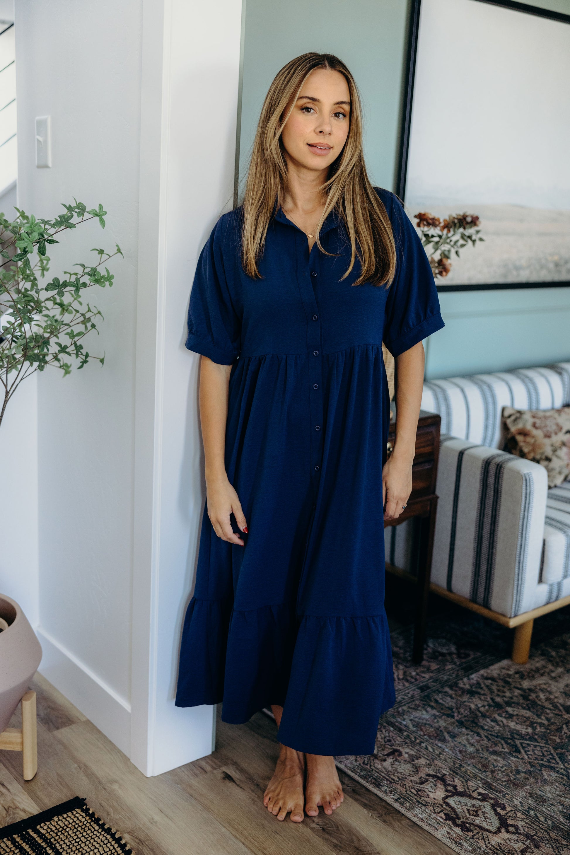 Button navy dress with half sleeves, natural waistline, and collar detail.
