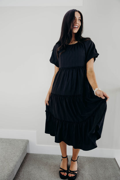 Black midi dress with round neckline and short sleeves.