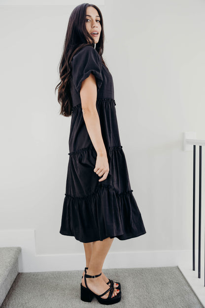 Ruffle tiered black textured dress with short puff sleeves.