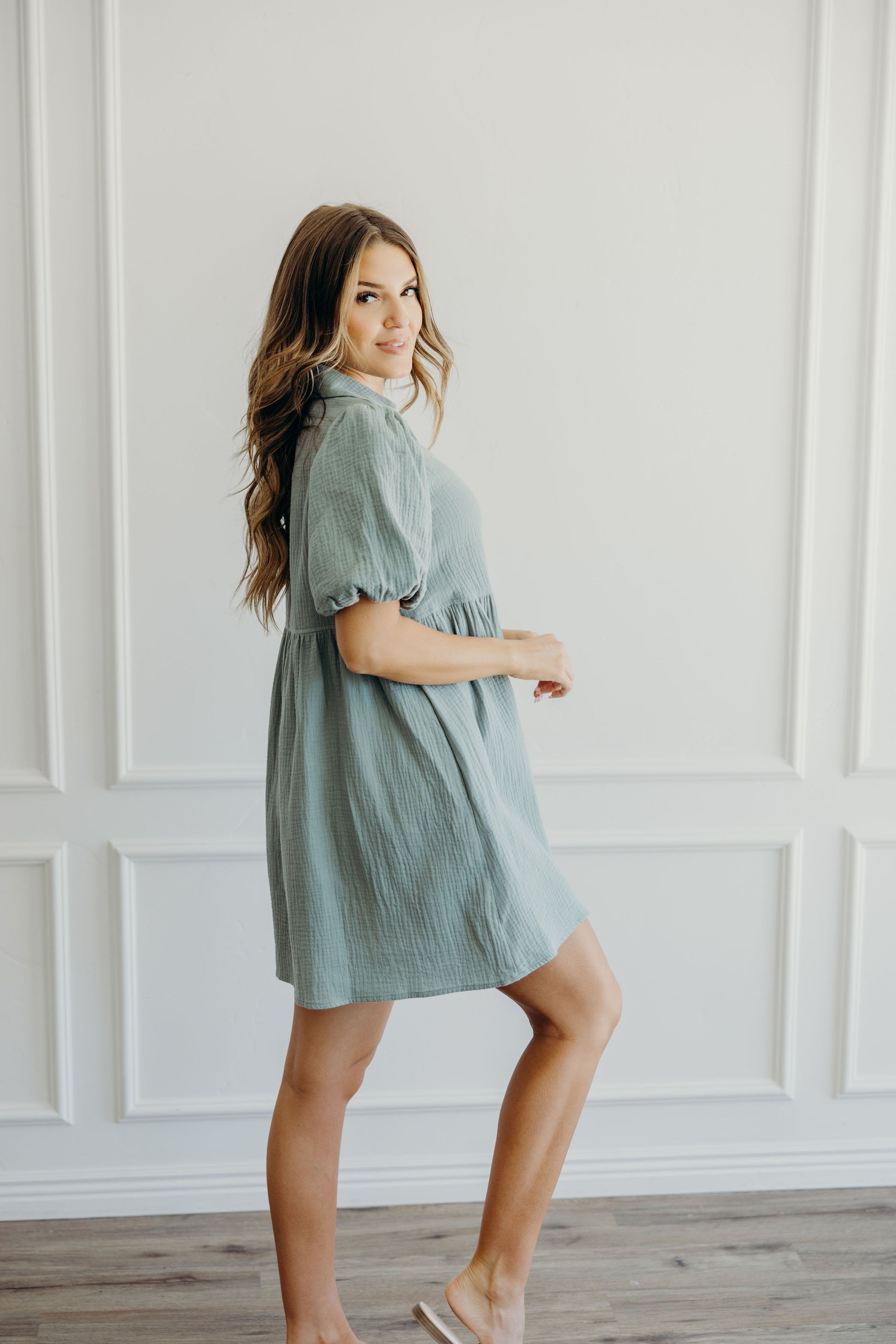 Knee length sage green dress with puff sleeves and collar detail.