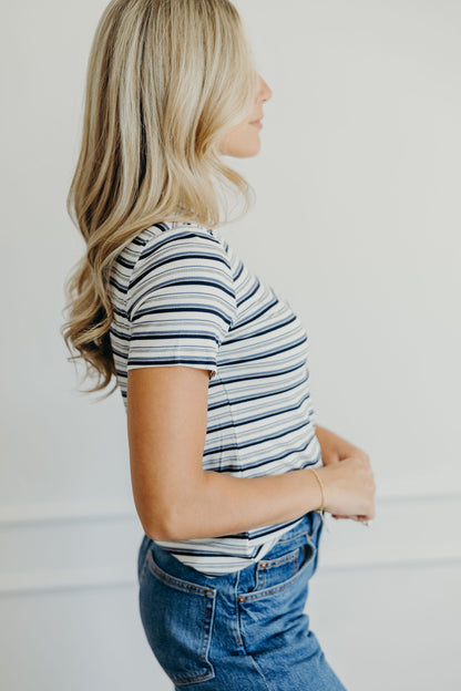 Blue, navy, gray, and white striped tee with short sleeves.