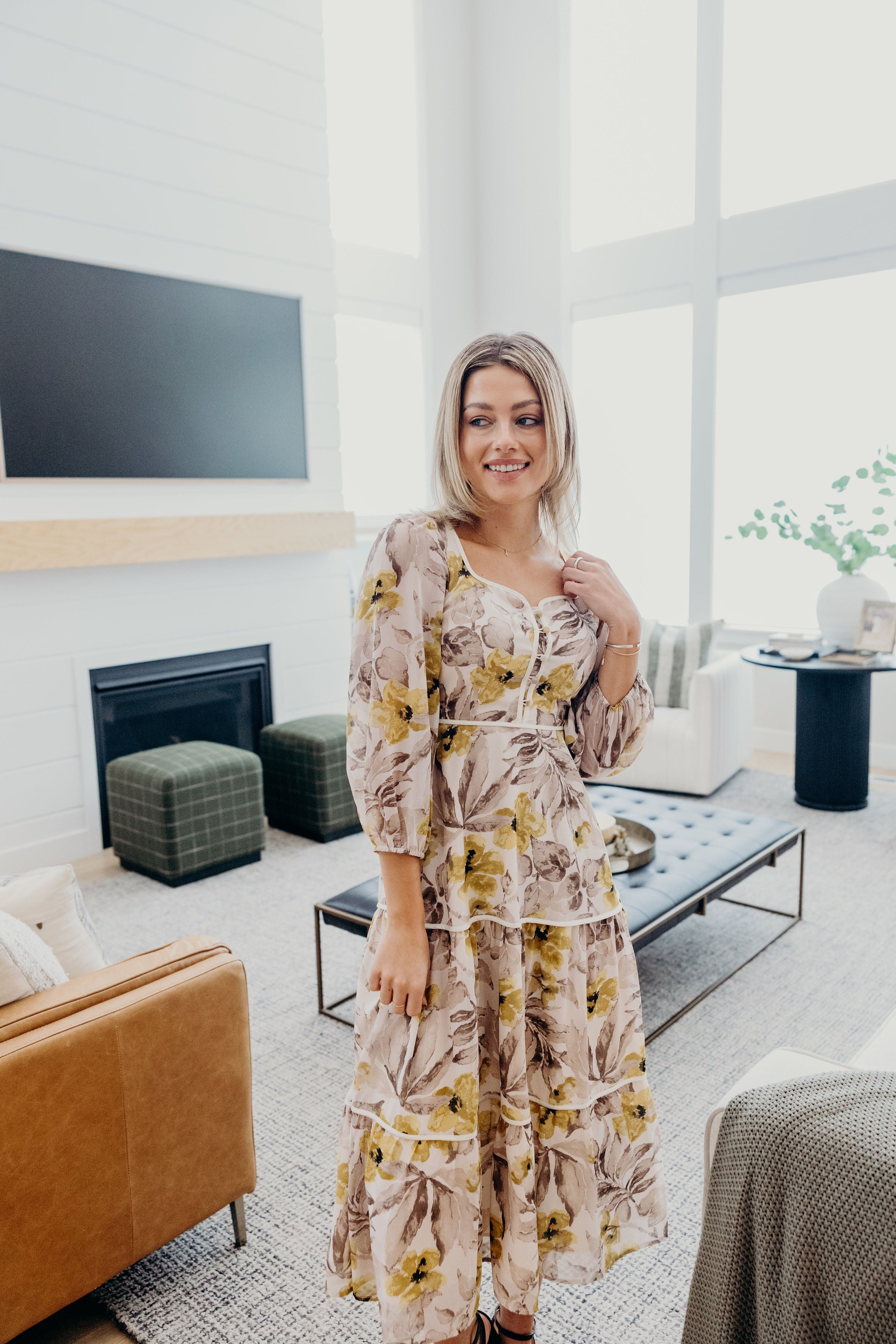 Tiered cream and gray floral print dress with piping and button detail with 3/4 sleeves.