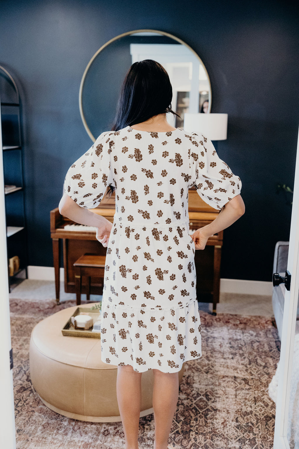 Back view of white and brown print floral dress with puff sleeves.
