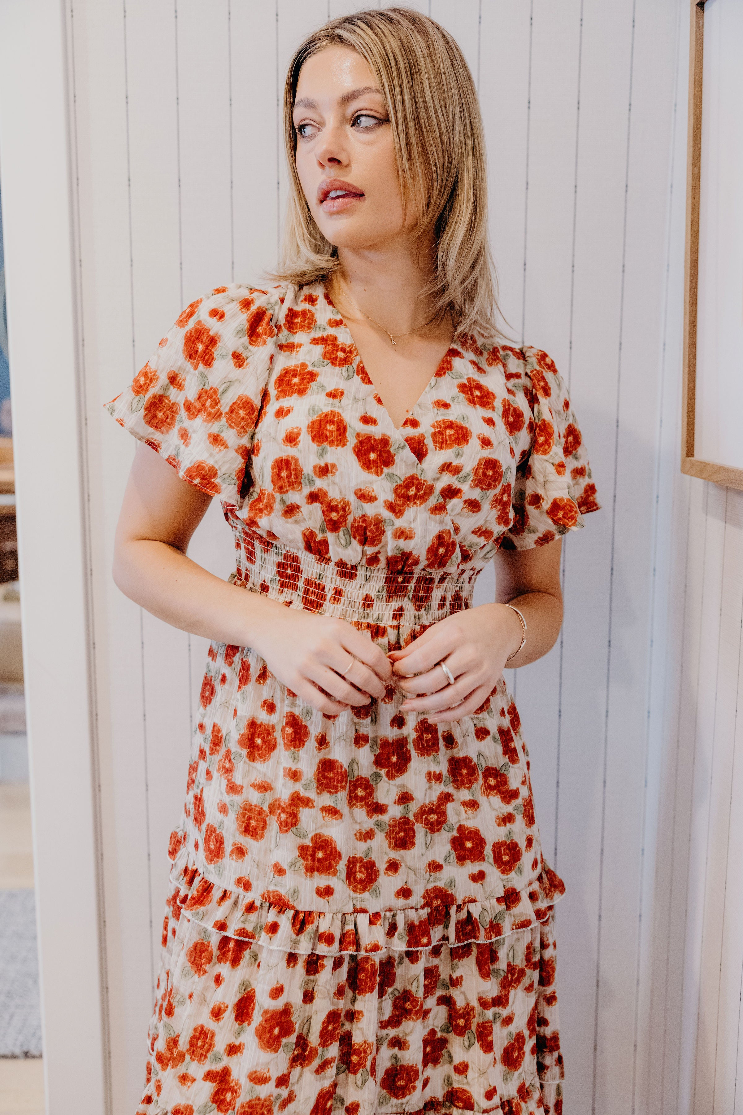 Red floral print dress with v neckline, smocked waist, and short sleeves.