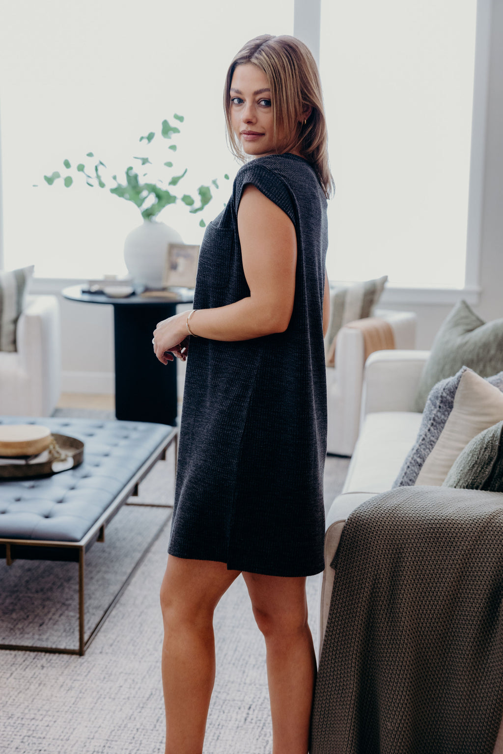 Short dark grey dress with cuff detail on sleeve.