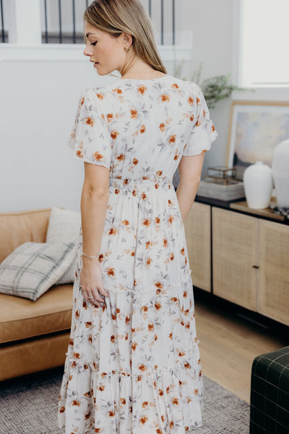 Back view of floral print dress with smocked waist and tiered skirt.