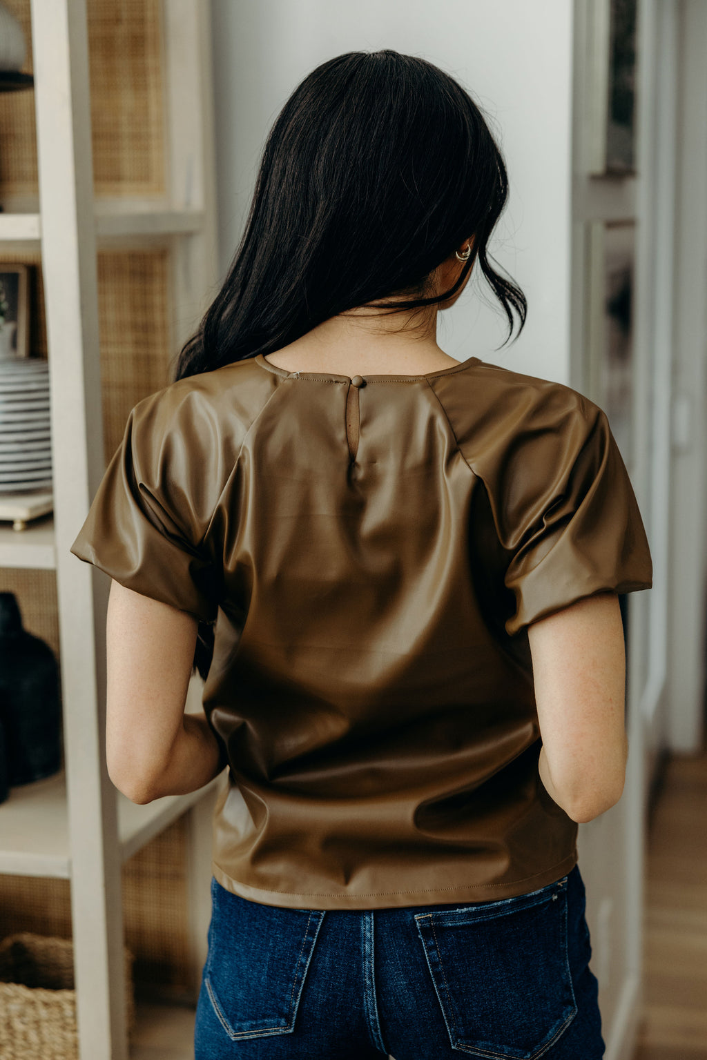 Back view of brown faux leather top with keyhole closure.