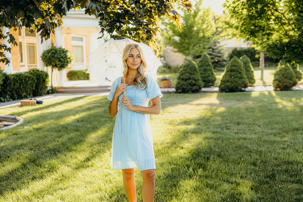 Short blue dress with textured detail and ruching on the bust.