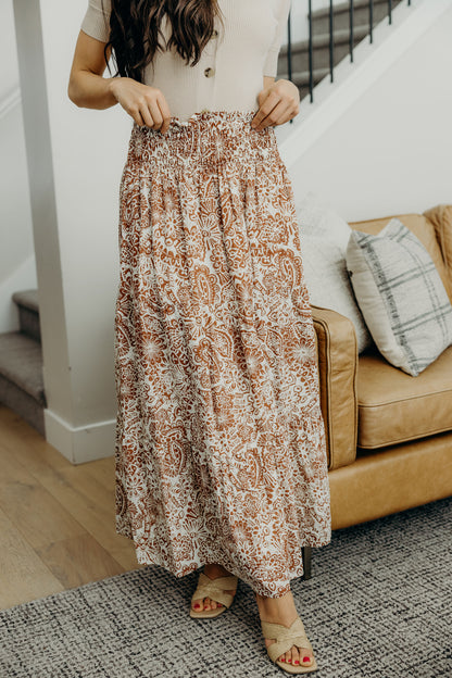 A line smocked waisted tiered maxi skirt with copper and cream paisley print.