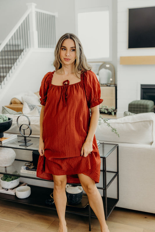 Knee length dress with square neckline and short sleeves.