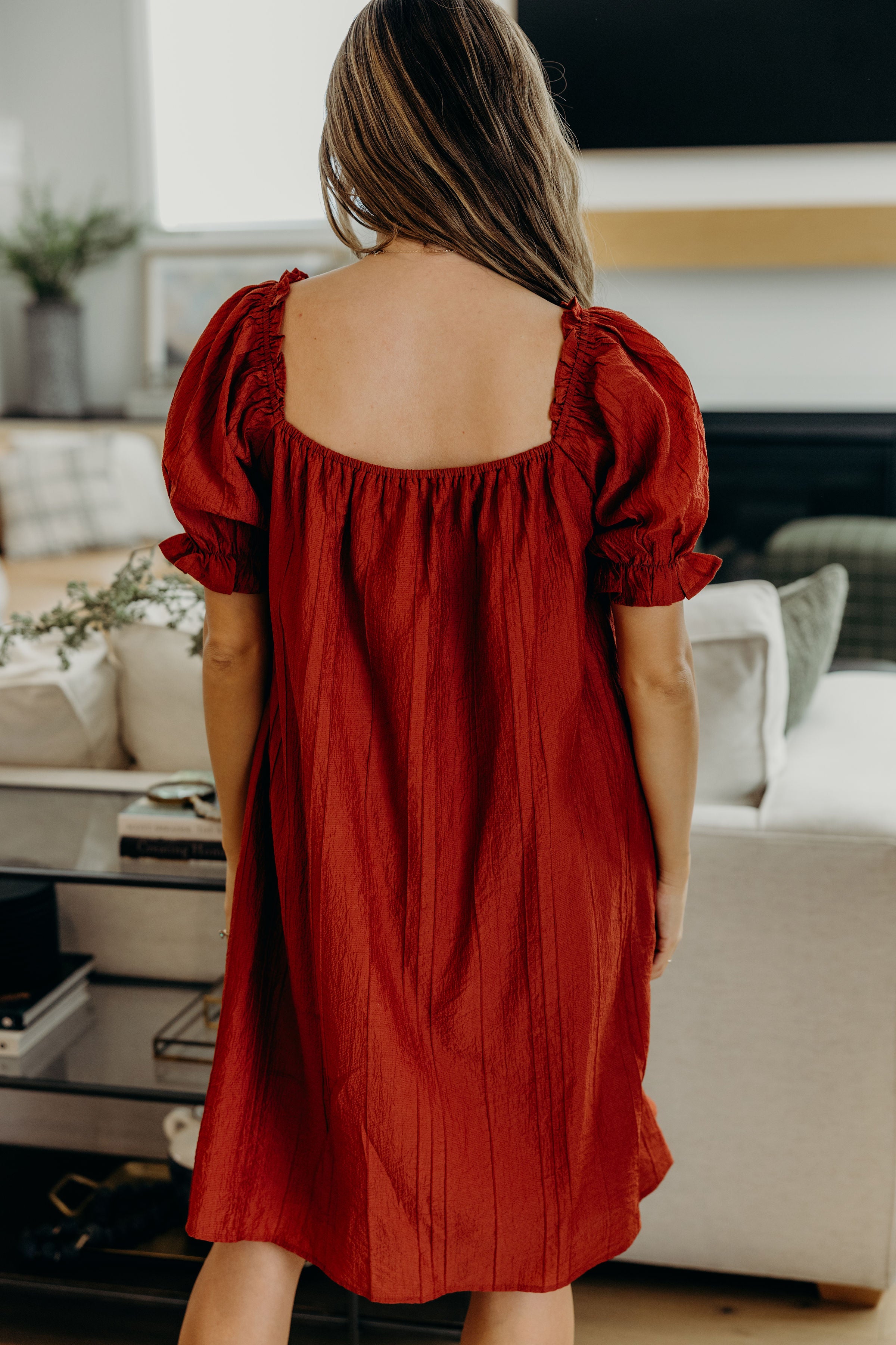 Back view of red textured dress with square neckline.